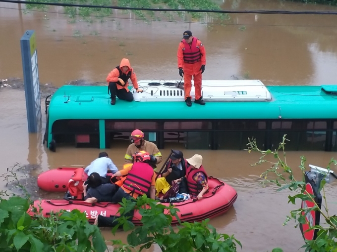 물에 잠긴 버스에서 승객 탈출시키는 구조대원들