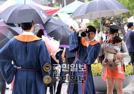 25일 서울 종로구 성균관대학교에서 열린 학위수여식에서 졸업생들이 빗속에서 기념사진을 찍고 있다. 국민일보 김지훈 기자