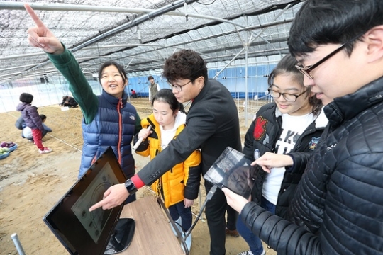 임자초등학교 어린이들이 KT IT 서포터즈와 함께 스마트팜에서 스마트기기를 연결해 농작물 관리법을 학습하고 있다.