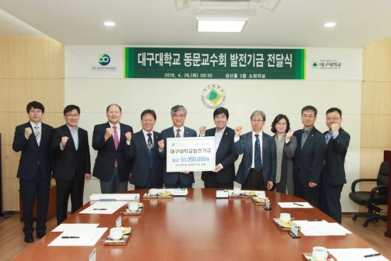 26일 대구대학교 동문교수회 정극원 회장이 홍덕률 총장에게 대학 발전기금을 전달하고 있다. <제공=대구대학교>